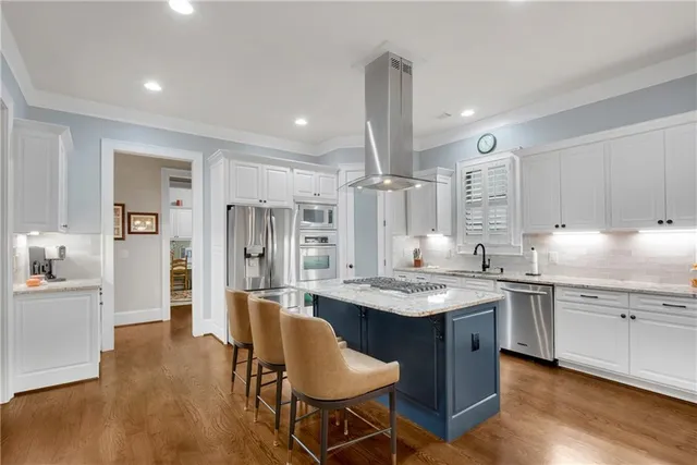 a kitchen with stainless steel appliances granite countertop a table chairs sink refrigerator and cabinets