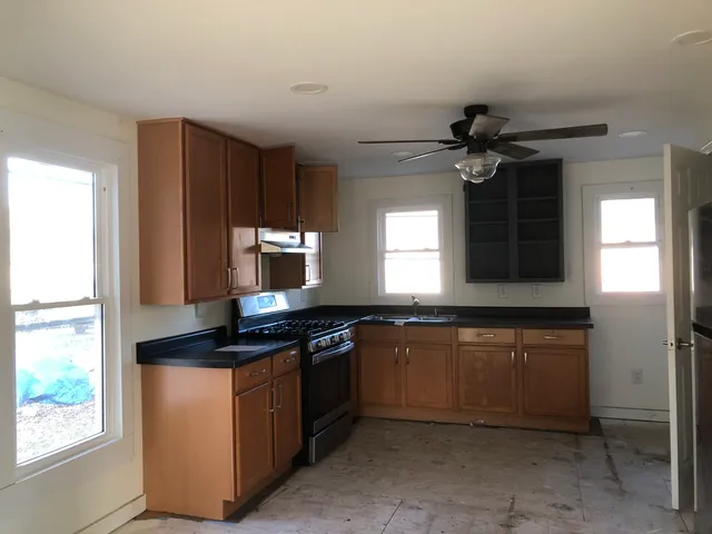 a kitchen with stainless steel appliances granite countertop a stove a sink and a microwave