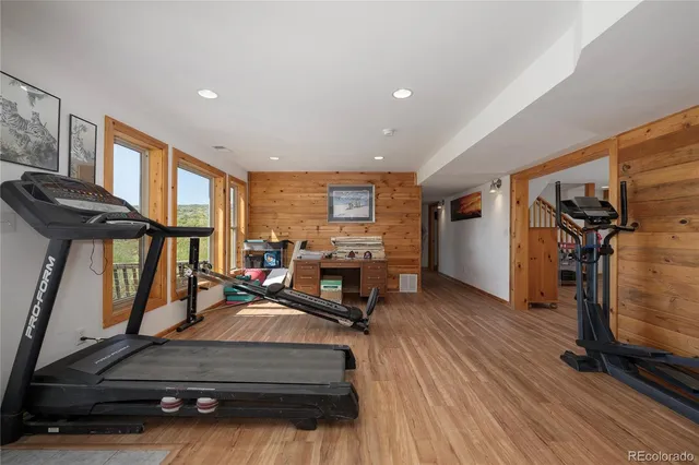 a living room with furniture gym equipment and a large window
