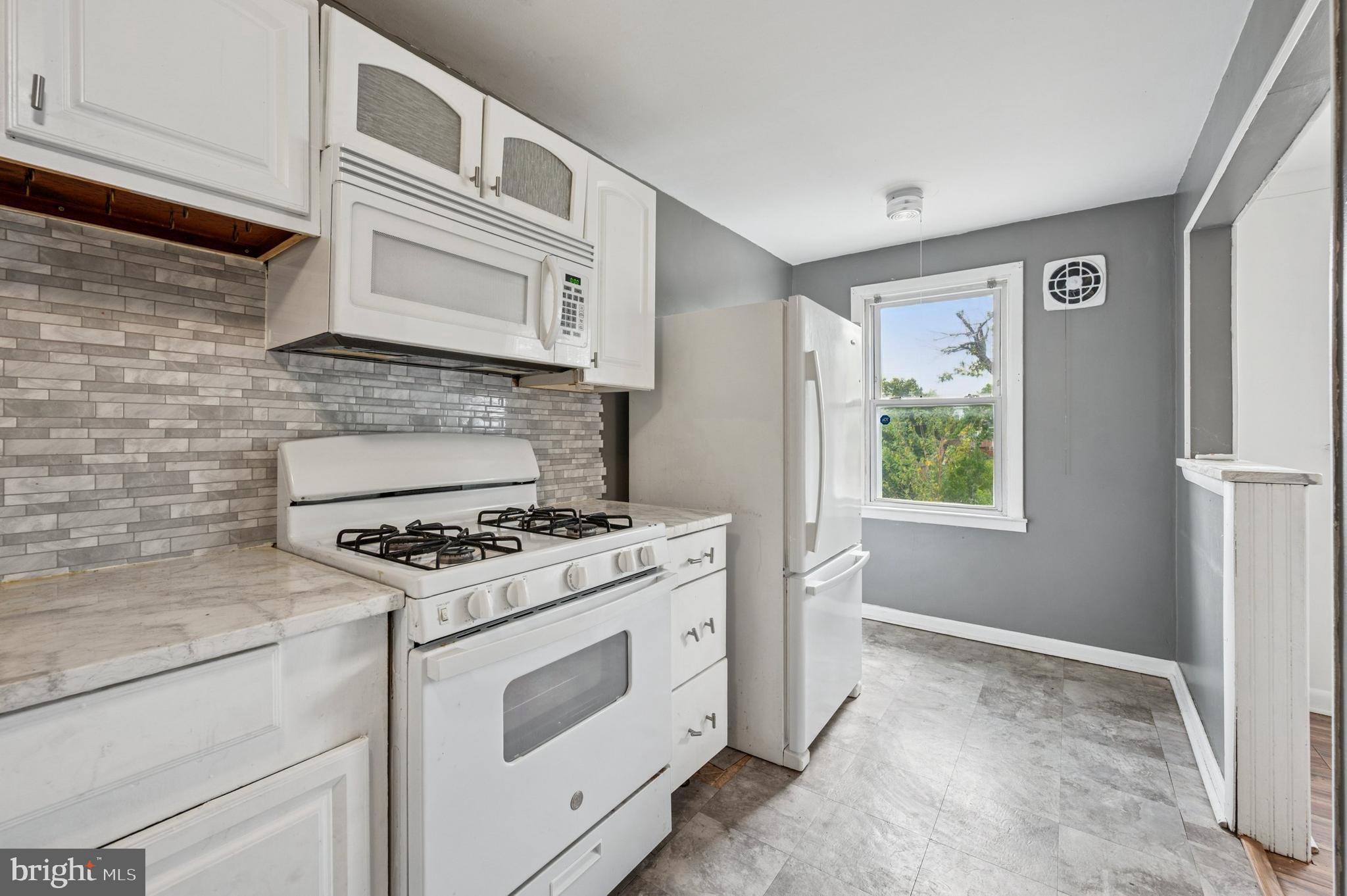 952 Grant Road Folcroft, PA 19032 - Photo 9 of 19 a kitchen with cabinets appliances and a window
