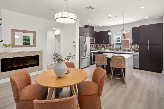 a kitchen with sink refrigerator dining table and chairs