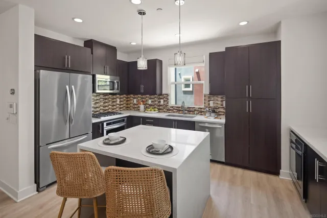 a kitchen with stainless steel appliances granite countertop a refrigerator a sink and wooden cabinets