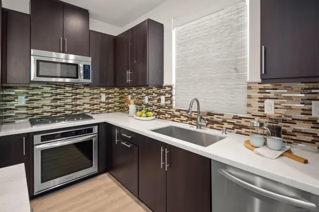 a kitchen with sink cabinets and stainless steel appliances