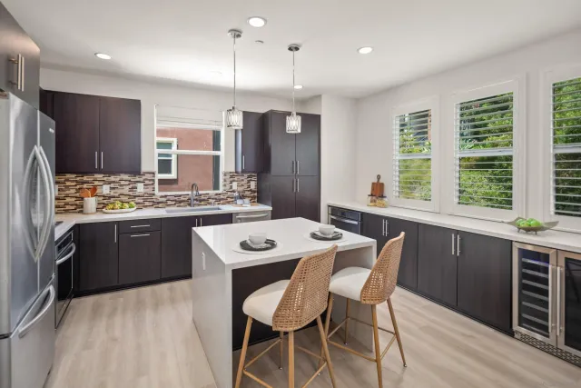 a kitchen with a table chairs stove refrigerator and cabinets