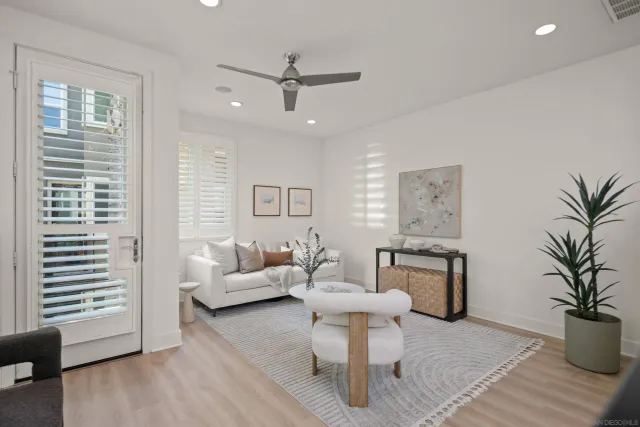 a living room with furniture a window and a potted plant