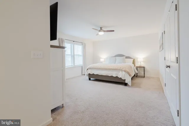 a spacious bedroom with a bed and a flat screen tv