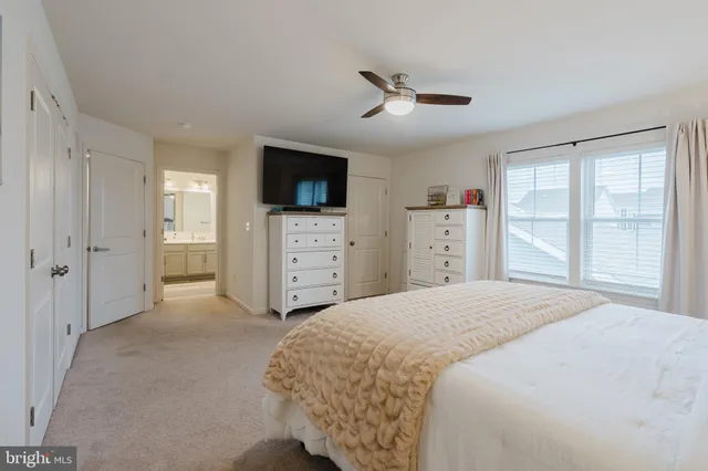 a spacious bedroom with a bed and a lamp