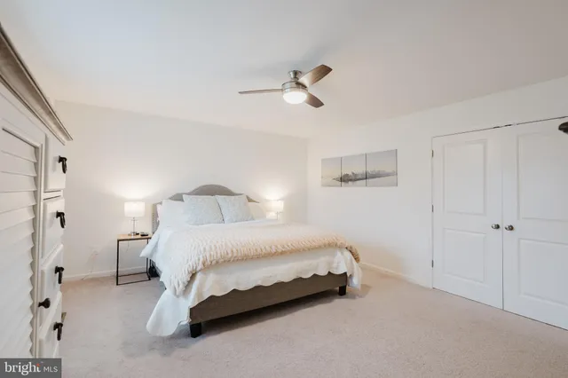 a bathroom with a toilet a sink a mirror a shower a vanity and window