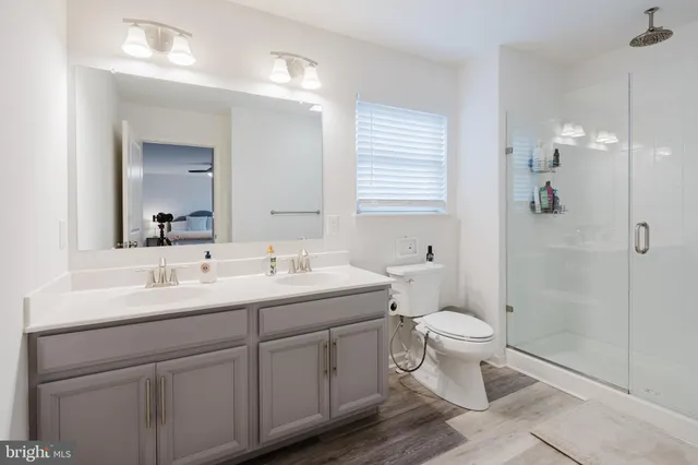 a bathroom with a sink a toilet and shower