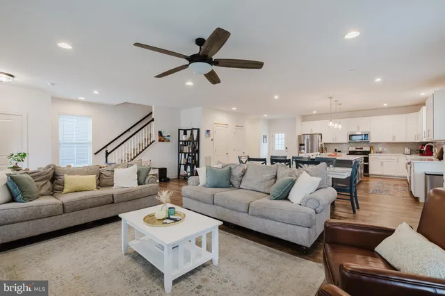 a living room with furniture and a view of kitchen