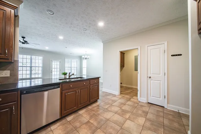 a kitchen with granite countertop wooden cabinets stainless steel appliances and a window