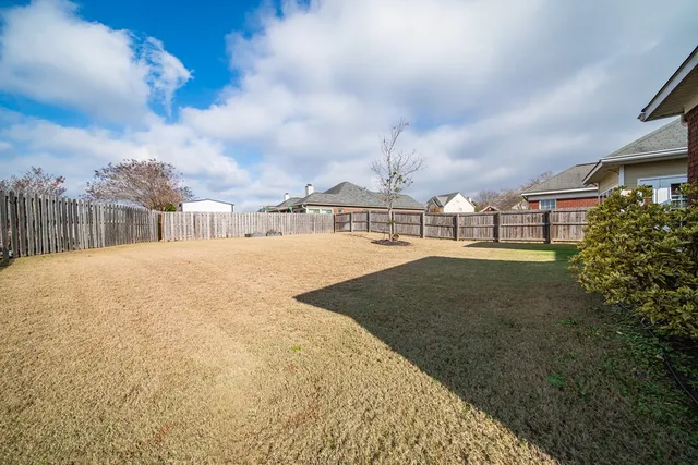 a view of swimming pool with a yard in front of it