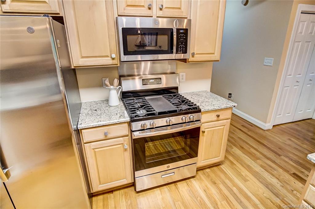 11121 Windgate Court Tega Cay, SC 29708 - Photo 18 of 44 a kitchen with stainless steel appliances granite countertop a stove microwave and sink