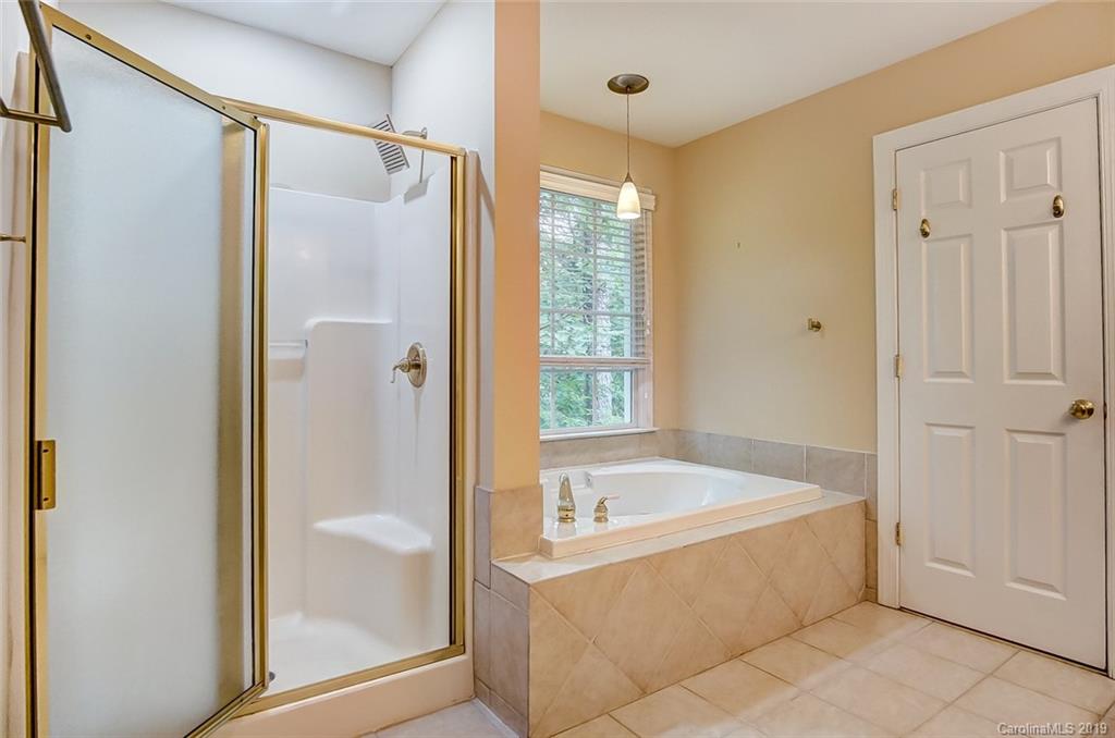 11121 Windgate Court Tega Cay, SC 29708 - Photo 33 of 44 a white bath tub sitting next to a shower