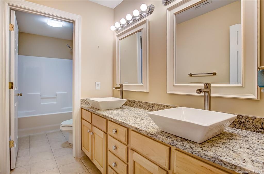 11121 Windgate Court Tega Cay, SC 29708 - Photo 35 of 44 a bathroom with a granite countertop sink and a mirror