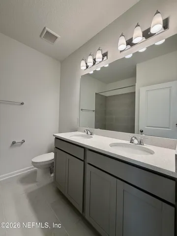 a bathroom with a double vanity sink and a mirror