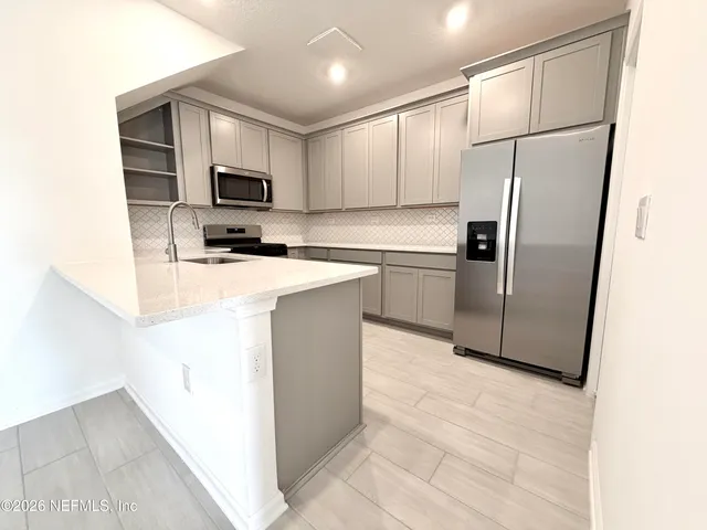a kitchen with stainless steel appliances a refrigerator sink microwave and cabinets