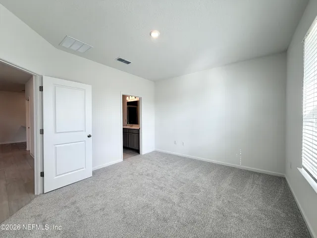 an empty room with an entryway and window