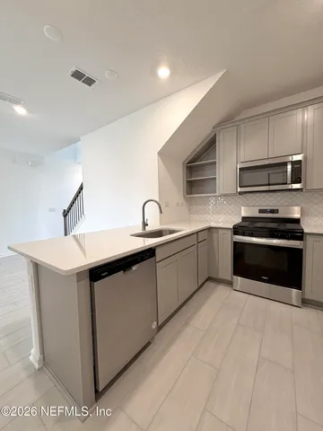 a kitchen with stainless steel appliances a sink stove and cabinets