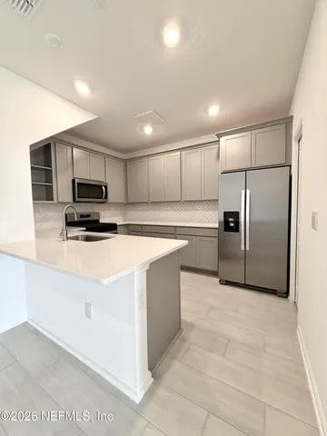 a large kitchen with cabinets and stainless steel appliances