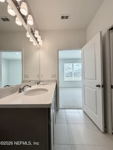 a bathroom with a sink vanity and a mirror