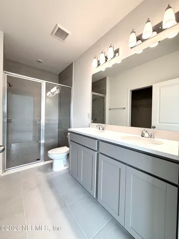 a bathroom with a double vanity sink mirror and toilet