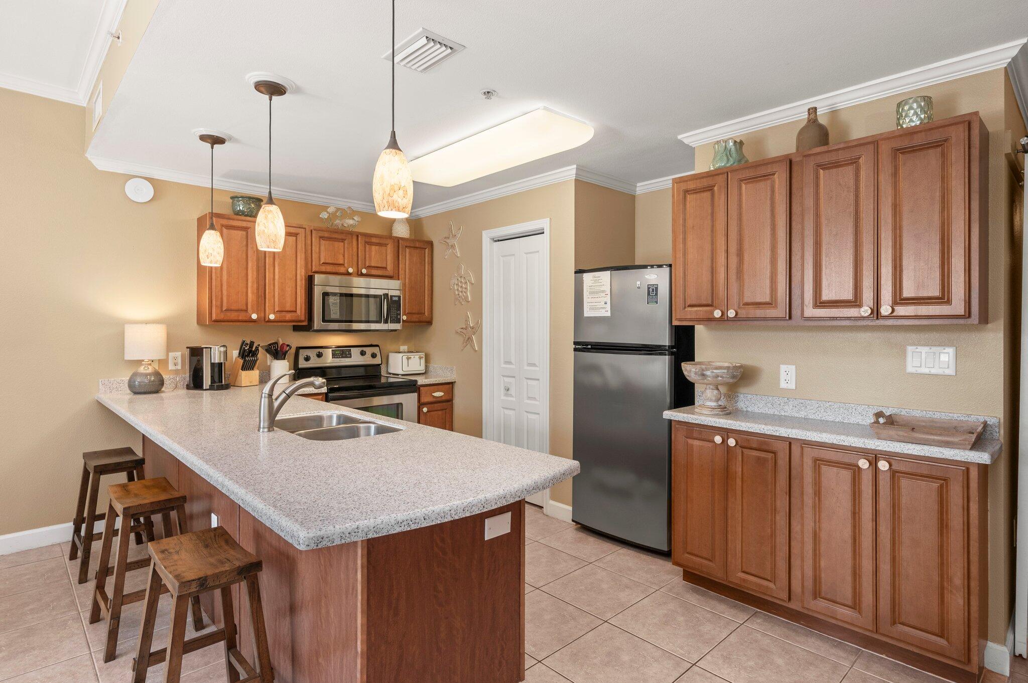 548 Sandy Cay Drive, Unit 203 Miramar Beach, FL 32550 - Photo 18 of 48 a kitchen with stainless steel appliances granite countertop a sink a stove a refrigerator a center island and cabinets