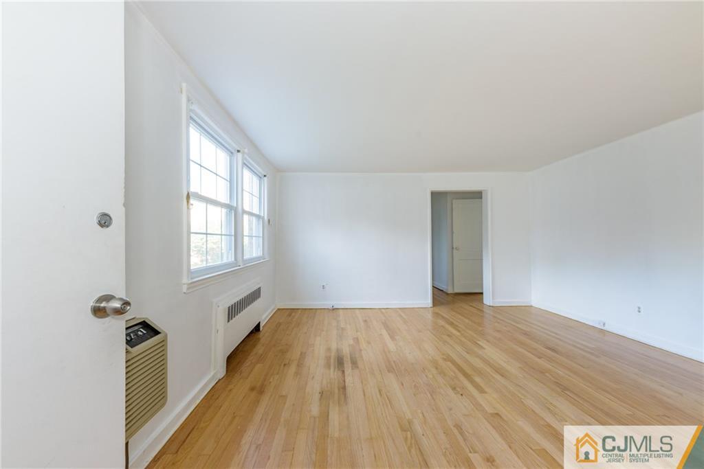 445 Morris Avenue, Unit D5 Springfield, NJ 07081 - Photo 3 of 21 an empty room with wooden floor and windows
