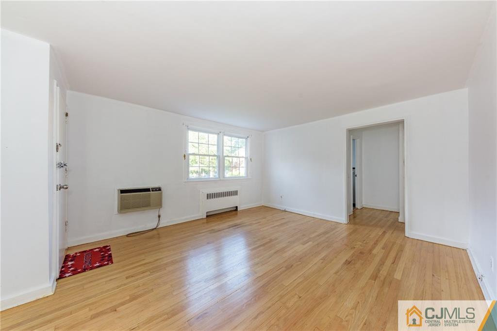 445 Morris Avenue, Unit D5 Springfield, NJ 07081 - Photo 6 of 21 a view of an empty room with wooden floor and a window