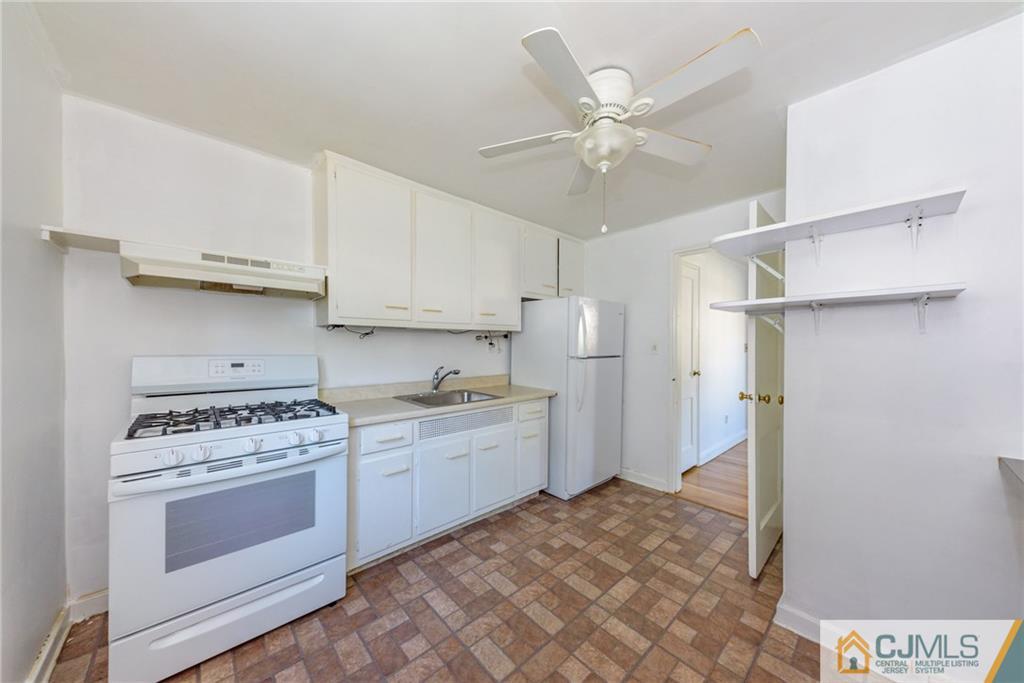 445 Morris Avenue, Unit D5 Springfield, NJ 07081 - Photo 9 of 21 a kitchen with a stove oven and white cabinets