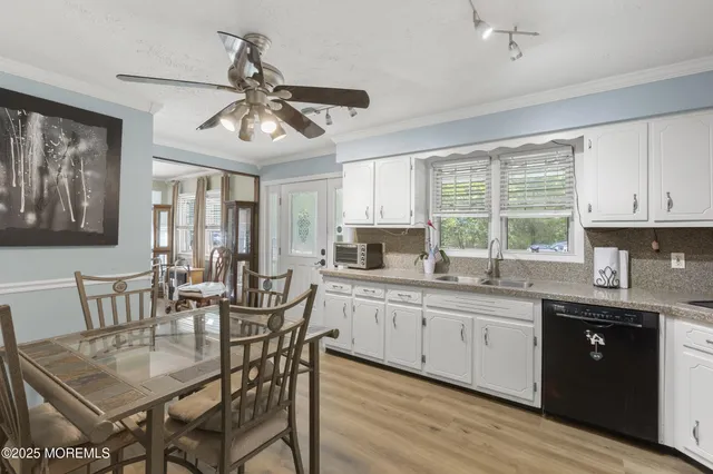 a kitchen with granite countertop a dining table chairs cabinets and stainless steel appliances