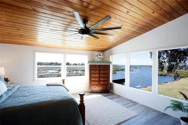 a bedroom with a bed and a large window with the outer view