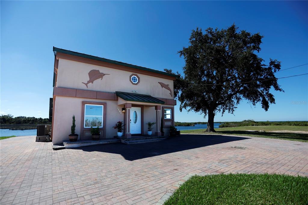 3194 Indian Gulf Lane Spring Hill, FL 34607 - Photo 30 of 38 a view of a house with a yard and palm trees