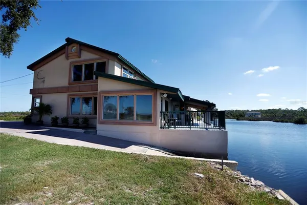 a front view of a house with a yard and lake view