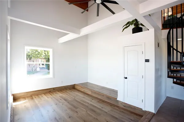 a view of a big room with wooden floor and windows