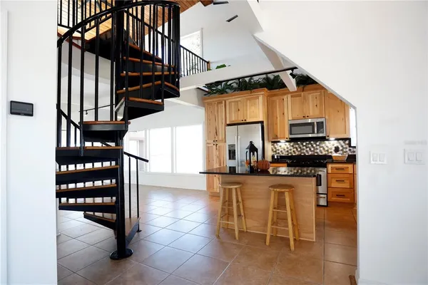 a kitchen with granite countertop a stove a sink and a microwave