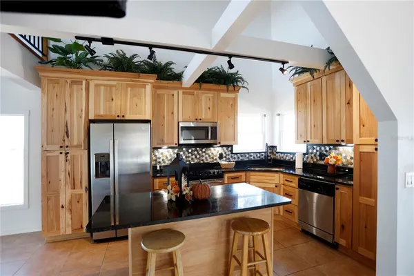 a kitchen with stainless steel appliances granite countertop a sink a refrigerator and a stove