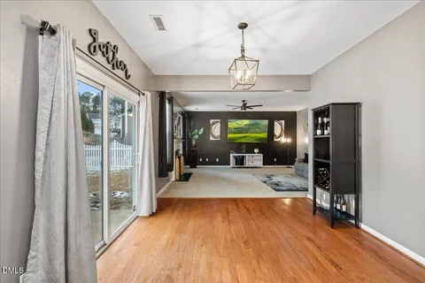 a kitchen with stainless steel appliances kitchen island granite countertop a refrigerator a stove top oven a sink dishwasher and white cabinets with wooden floor