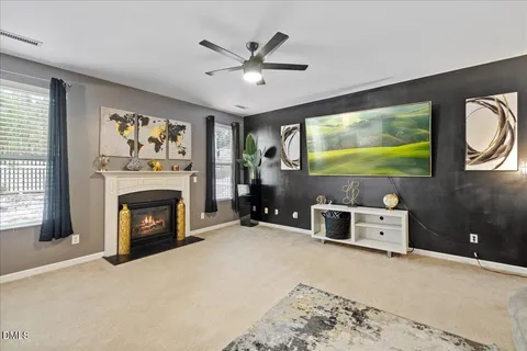 a living room with furniture a fireplace and a floor to ceiling window