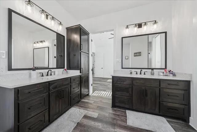 a spacious bathroom with double vanity and a mirror