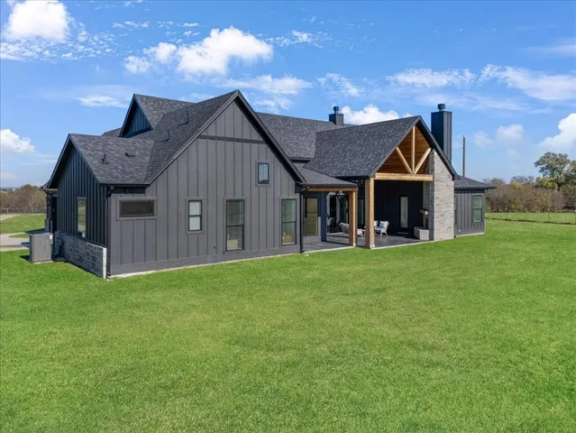 a view of a big house with a big yard and large trees