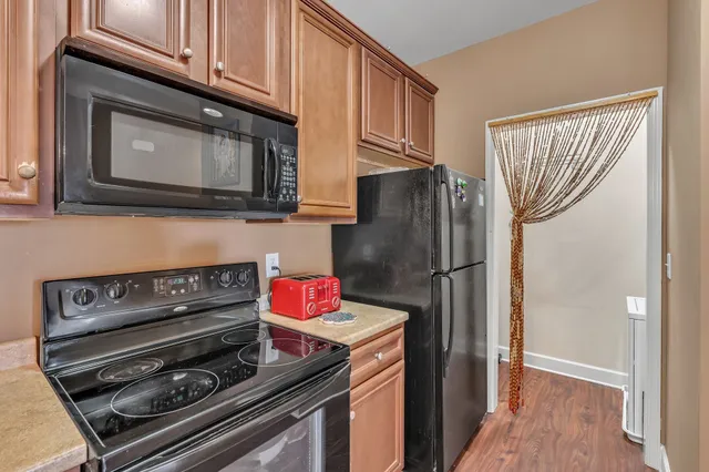 a kitchen with granite countertop a refrigerator stove and microwave
