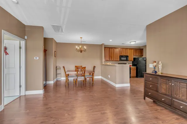 a kitchen with stainless steel appliances wooden floor and dining table