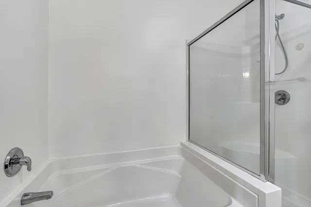 a bathroom with a tub sink and mirror