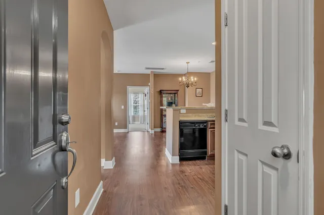a view of a hallway with wooden floor fireplace and a window