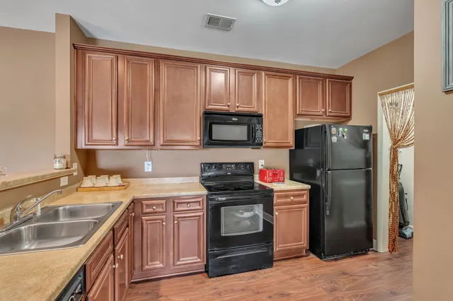 a kitchen with granite countertop a refrigerator stove and sink