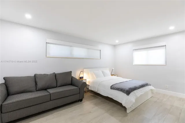 a bedroom with a bed couch and a window