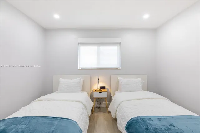 a bedroom with two beds and a window