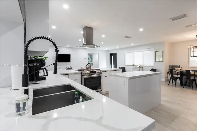 a kitchen with a sink stainless steel appliances and white cabinets