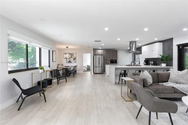 a living room with furniture and kitchen view